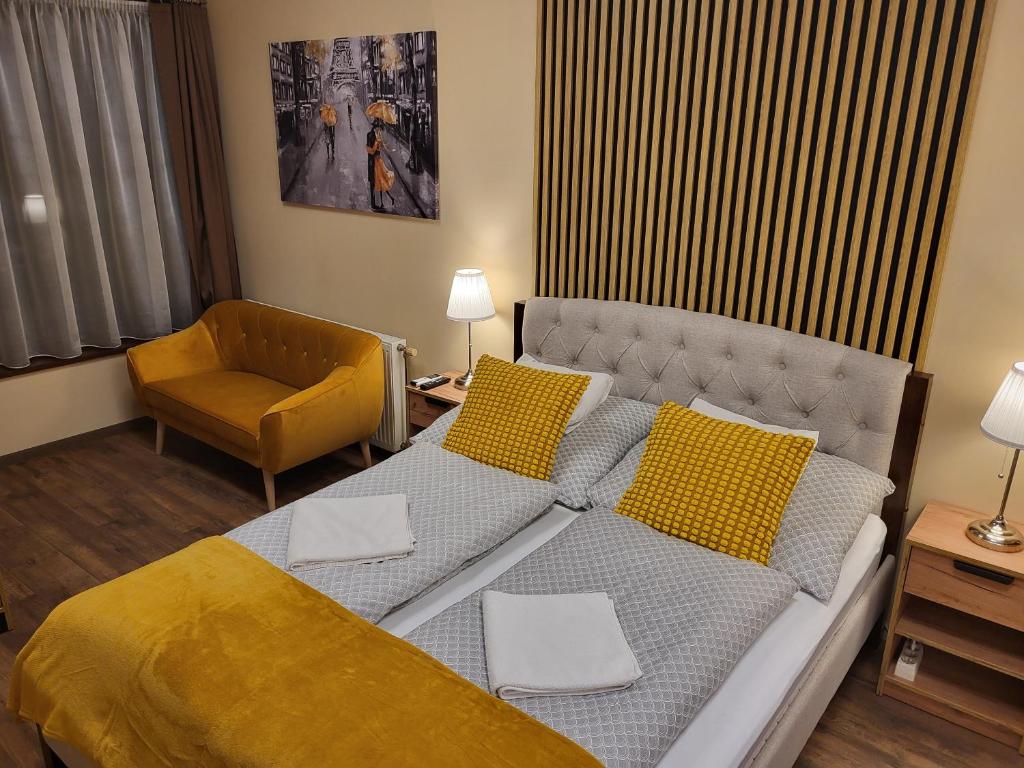 a bedroom with a bed and a couch and a chair at Glória Apartman Szarvas in Szarvas