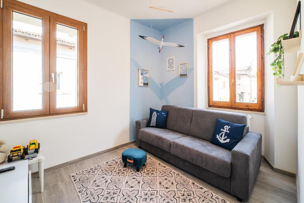 ein Wohnzimmer mit einem Sofa und 2 Fenstern in der Unterkunft La Casetta del Porto in Pesaro
