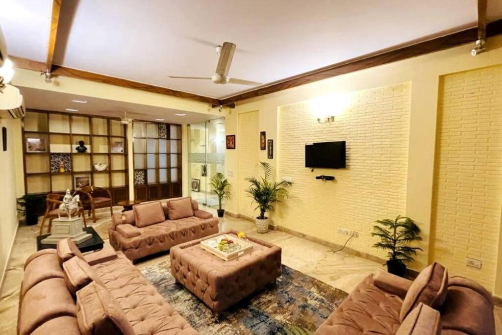 una gran sala de estar con sofás y TV de pantalla plana. en Fortune Home Service Apartment 4Bhk,D-36, Saket, en Nueva Delhi