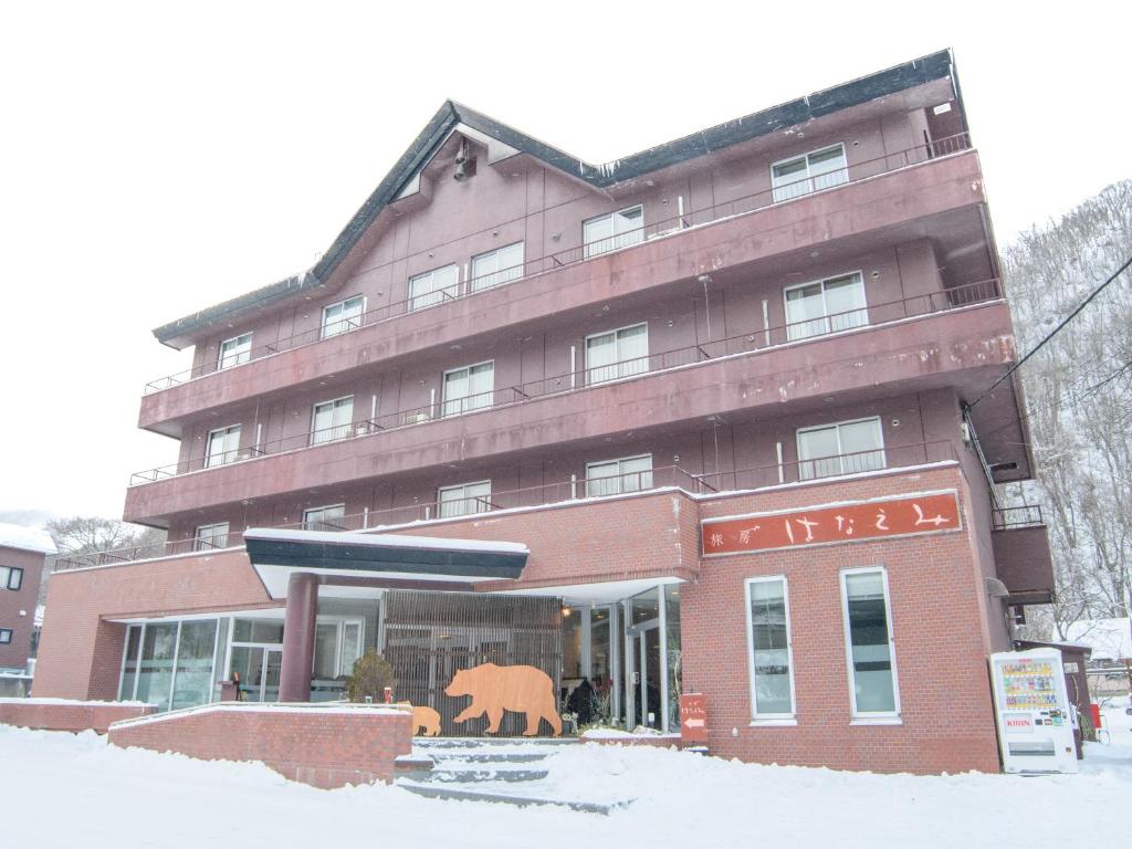 un grand bâtiment marron avec un ours à la fenêtre dans l'établissement Ryokan HANAEMI, à Otaru