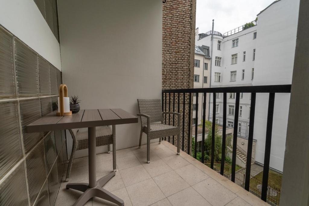 a balcony with a table and chairs and a view of a building at Pakat Residences in Vienna