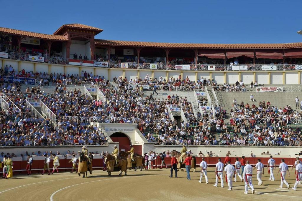a large crowd of people watching a horse show in an arena at Hôtel du Champs de Mars in Béziers
