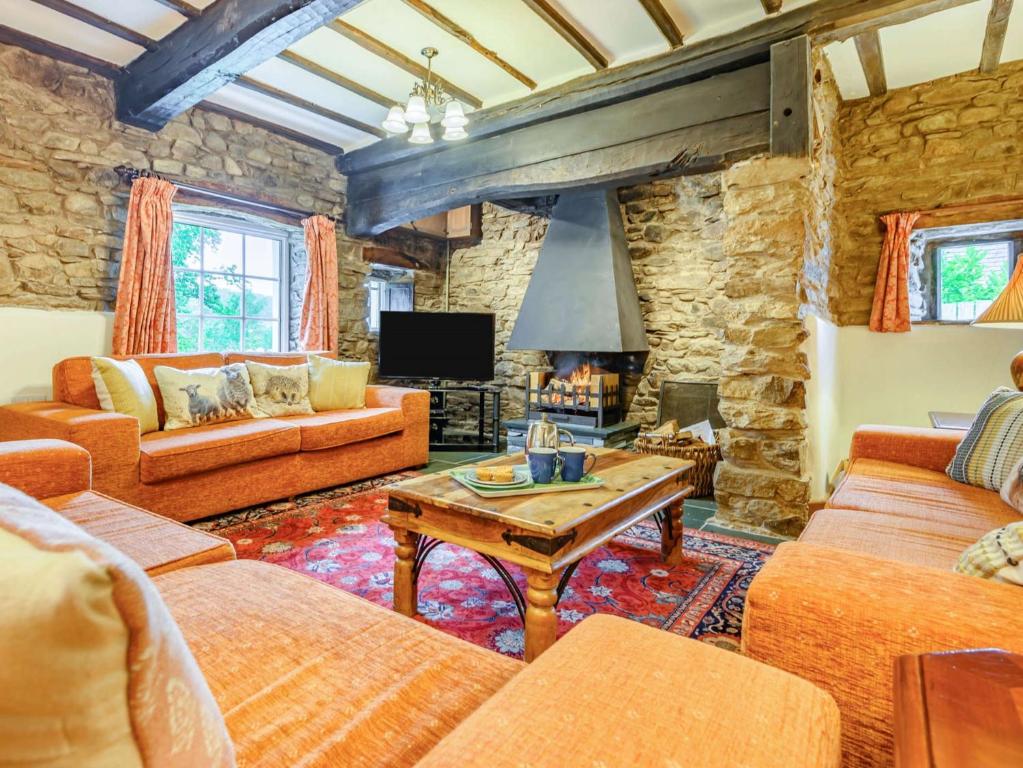 a living room with orange furniture and a stone wall at 4 Bed in Routenbeck SZ405 in Bassenthwaite Lake