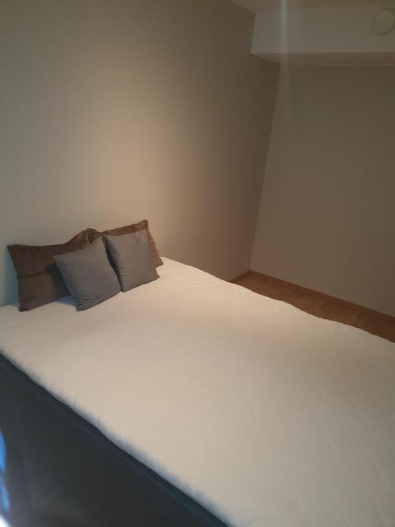 a bedroom with a white bed with two pillows at Cosy 1bedrom apartment in Lorenskog