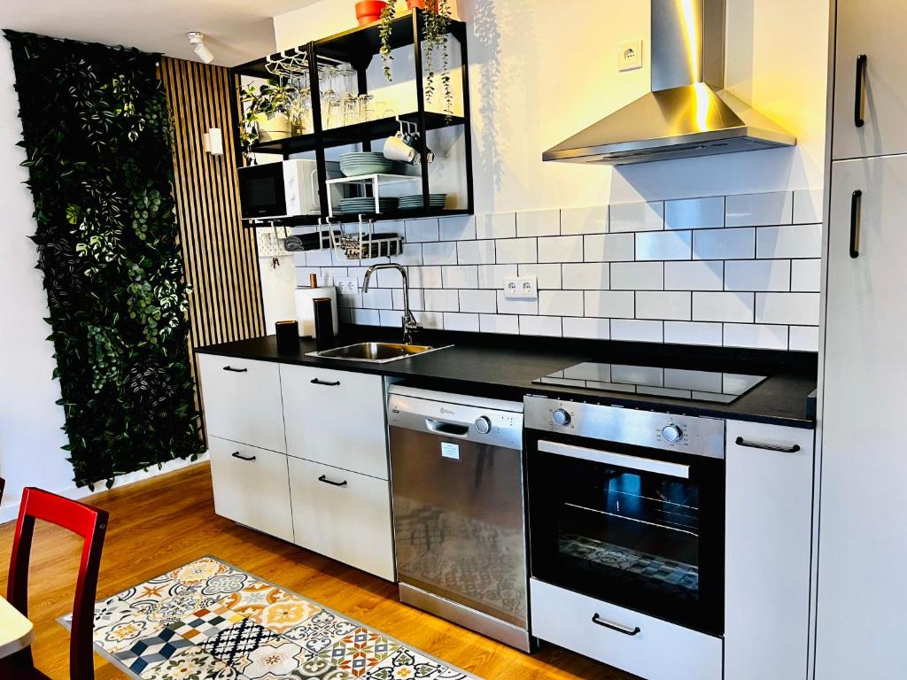 uma cozinha com armários brancos e um forno com placa de fogão em SG Apartamentos - LA CASA DE SOFÍA VUT-47-14 em Valladolid