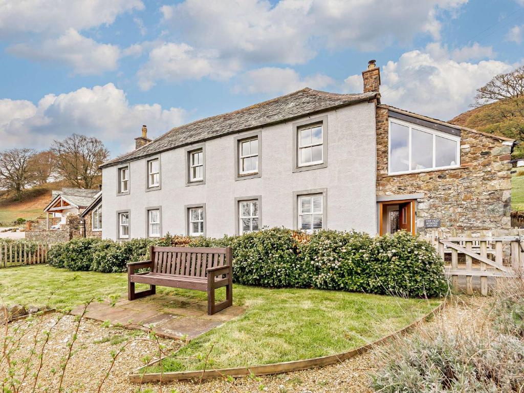 a large stone house with a bench in the yard at 4 Bed in Matterdale SZ367 in Dockray