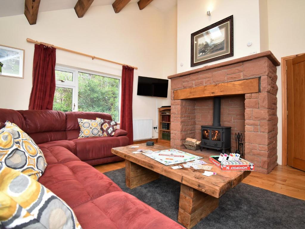 a living room with a red couch and a fireplace at 4 Bed in Langwathby SZ103 in Langwathby