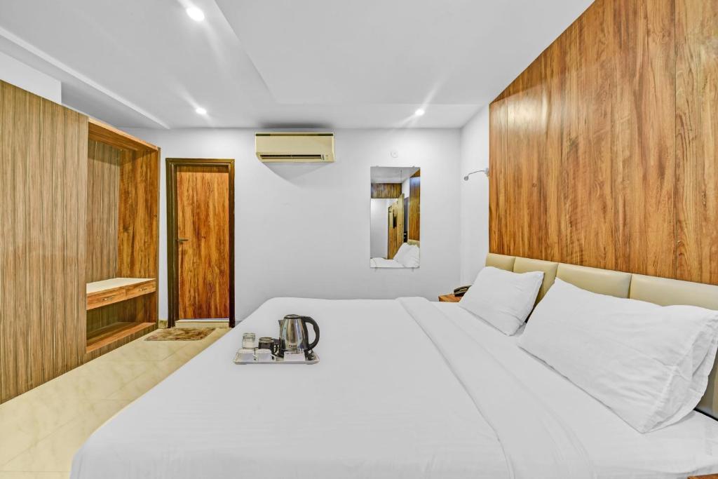 een slaapkamer met een wit bed en een houten muur bij OYO Townhouse 801 The Circle in Jaipur