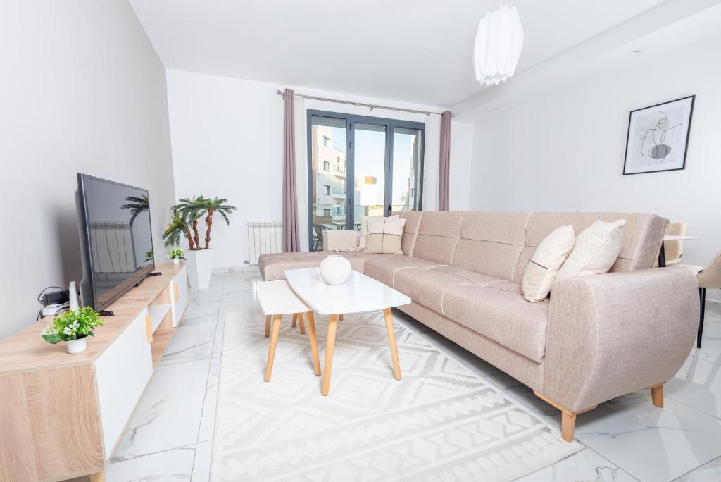 a white living room with a couch and a tv at Appartement Luxueux à Draria in Draria