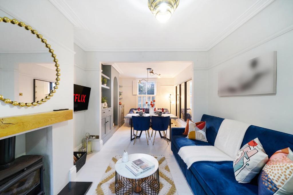 een woonkamer met een blauwe bank en een tafel bij Lux 3 Bed London House - Garden in Londen