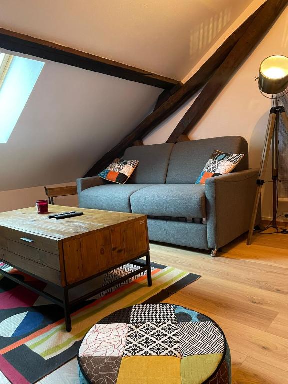 a living room with a couch and a coffee table at Atypique et central : 4 personnes + Parking privé in Bourges