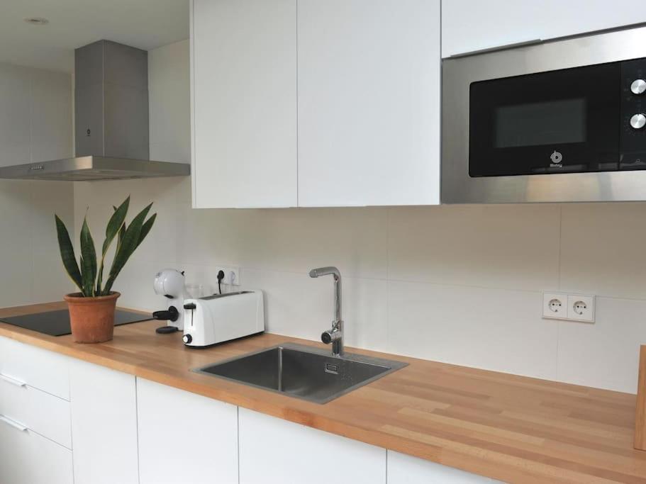 eine Küchentheke mit Spüle und Mikrowelle in der Unterkunft Apto a 1 minuto de la Playa en Sant Antoni in Sant Antoni de Calonge