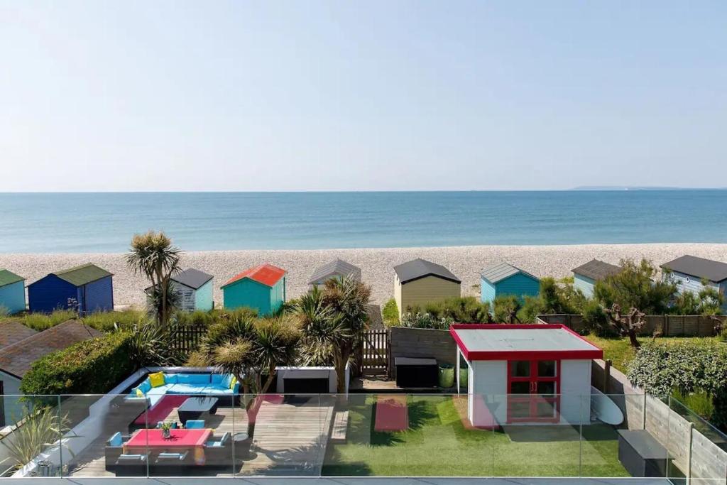a view of a beach with houses and the ocean at The Kite House in East Wittering
