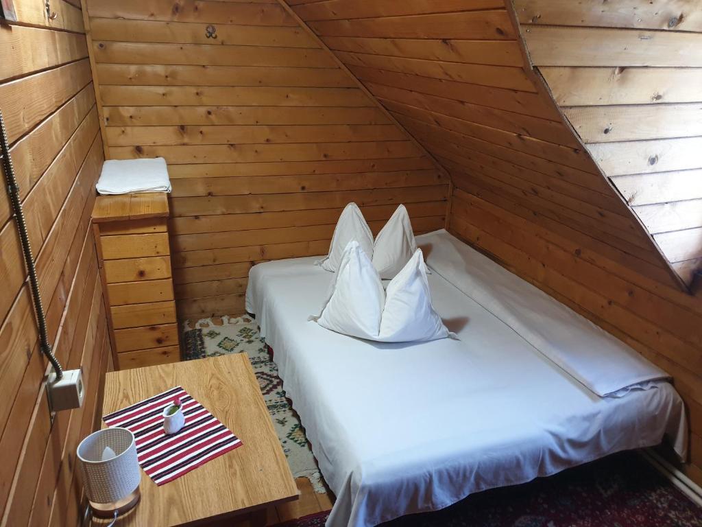 a room with a bed in a wooden cabin at Casa Lacramioara in Sîmbăta de Sus