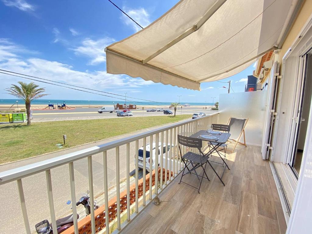 un balcon avec une table et des chaises et une vue sur la plage dans l'établissement Superbe appartement avec vue mer, à Narbonne-Plage