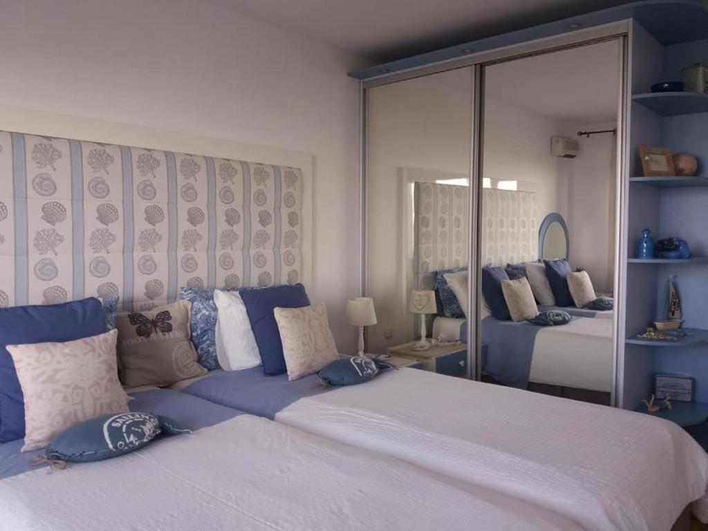 a bedroom with a large white bed with blue pillows at Villa Bellerose in Bozhurets