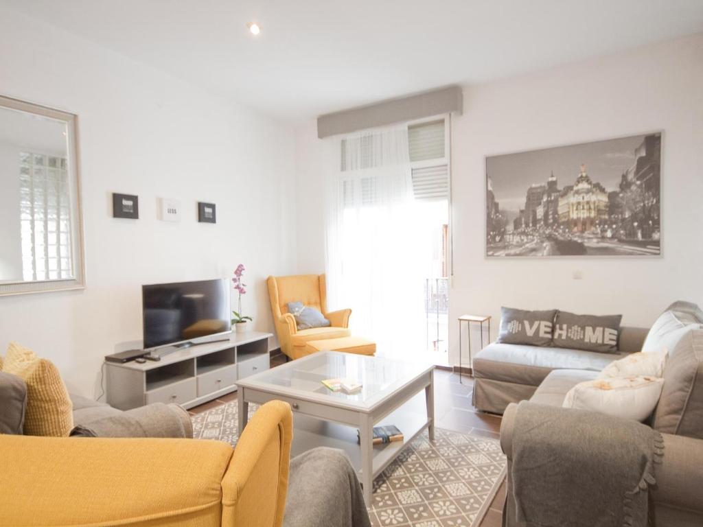sala de estar con sofá y mesa en Enorme y acogedor piso en la puerta del sol en Madrid