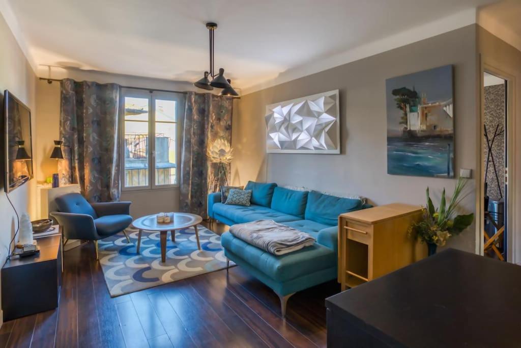 un salon avec un canapé bleu et une table dans l'établissement #39 Old Town suite 3 BDR AC Balcony 5mins Walk to Sea, à Nice