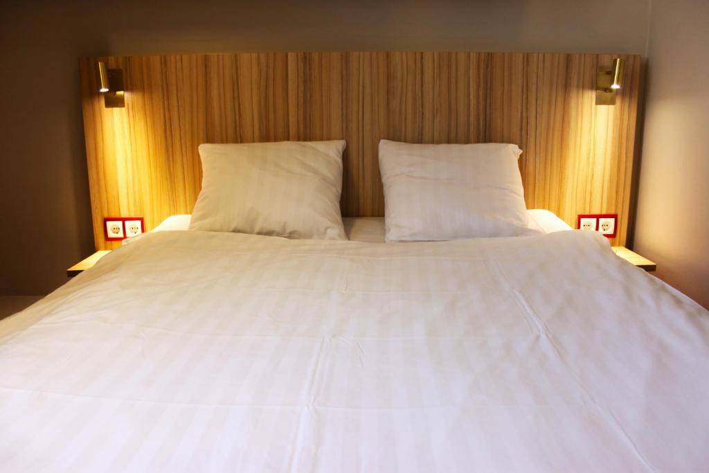 a large white bed with two pillows on it at Good Morning Västerås in Västerås