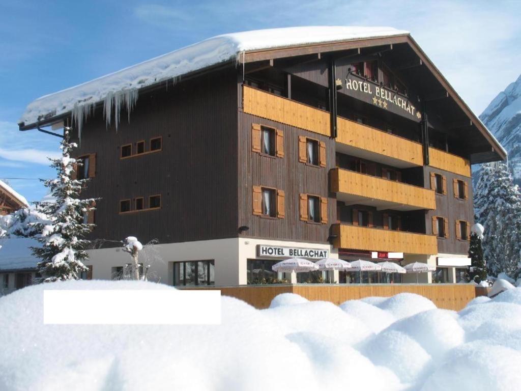 un edificio con la neve davanti di Hôtel Bellachat a La Clusaz