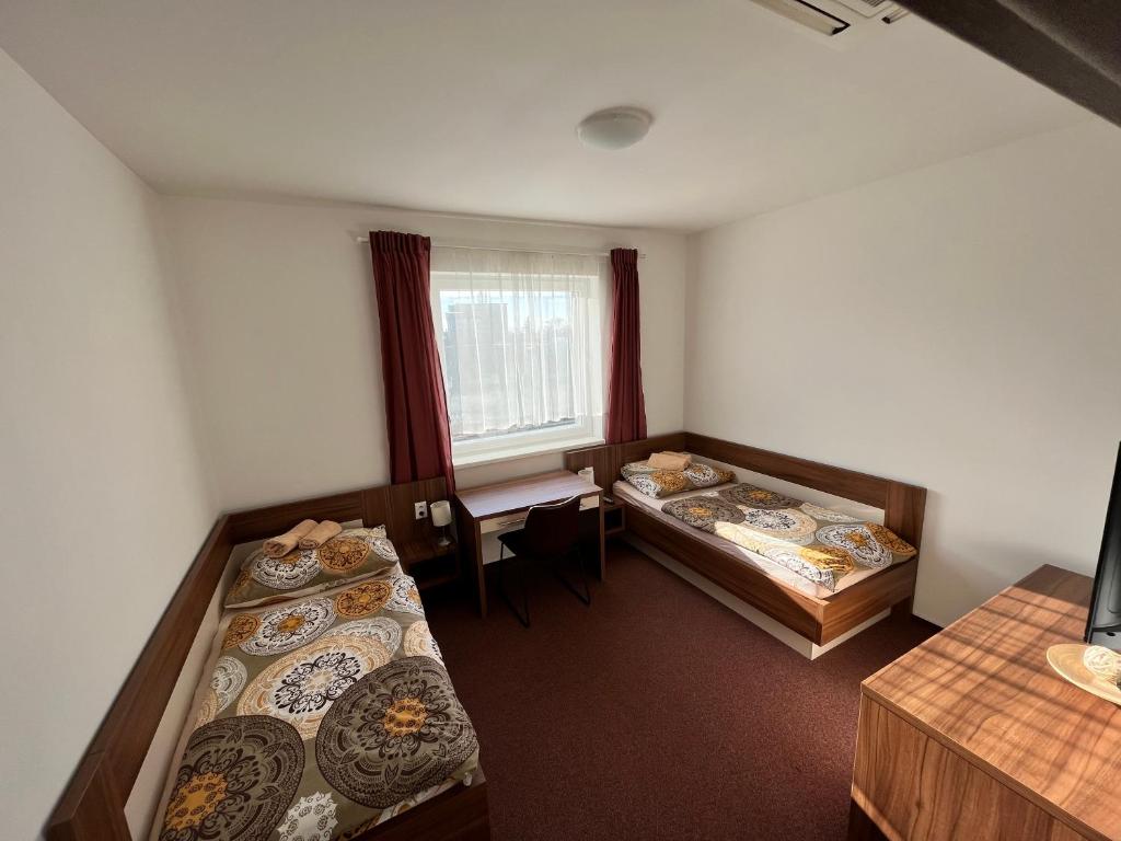 um quarto com duas camas e uma janela em Ubytovanie pod Bielymi Karpatmi em Nové Mesto nad Váhom