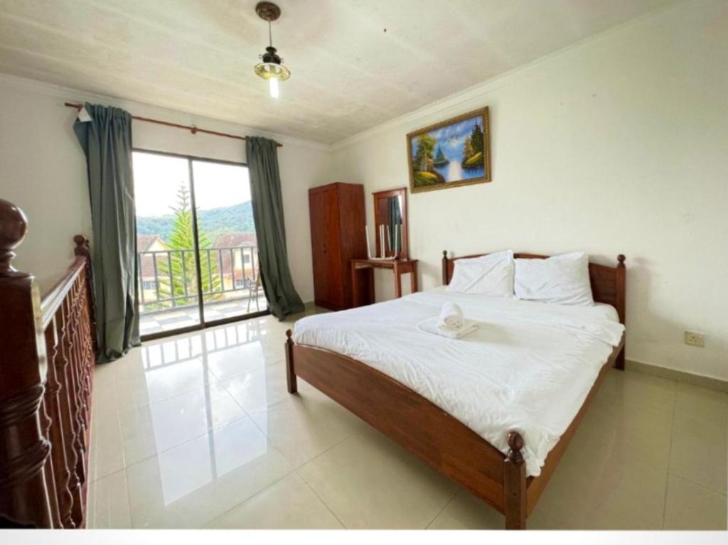 1 dormitorio con cama y ventana grande en PLAY at Arabella Tudor House, en Tanah Rata