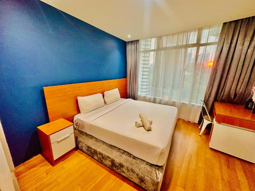 Un dormitorio con una cama con un osito de peluche. en near klcc vortex suites by PLUS POIN en Kuala Lumpur