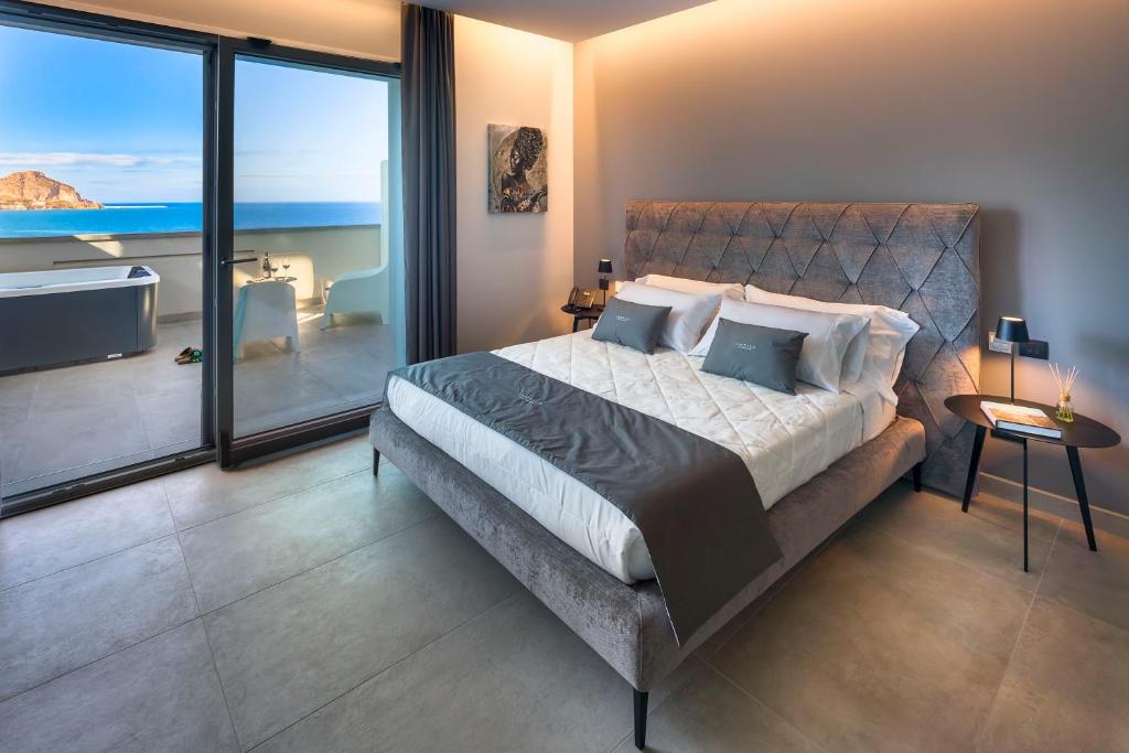 um quarto com uma cama e vista para o oceano em Emerald Hotel Residence Cefalù em Cefalù