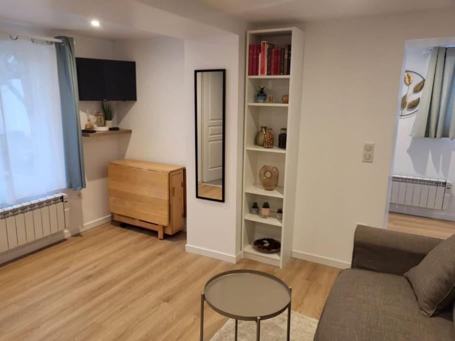 un salon avec un canapé, une table et un miroir dans l'établissement Le petit RepOzoir, une halte entre Paris et Disney, à Ozoir-la-Ferrière