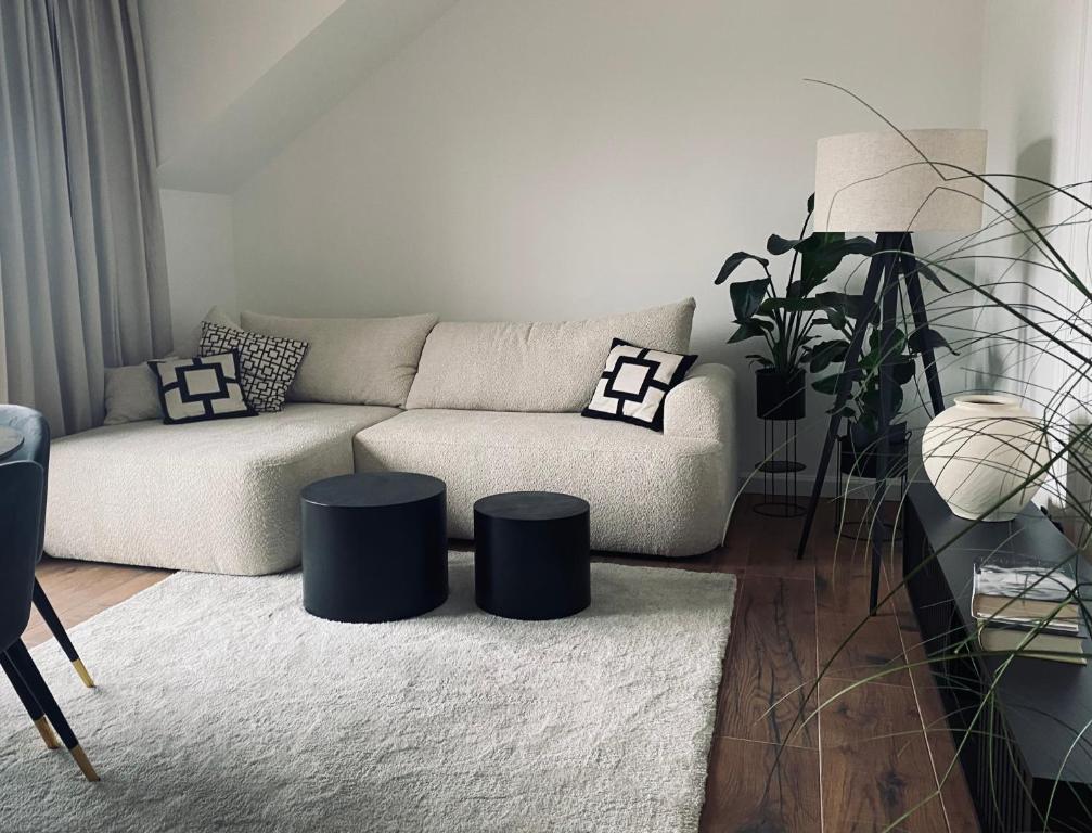 a living room with a couch and two stools at Apartamenty Zuzanny in Mińsk Mazowiecki