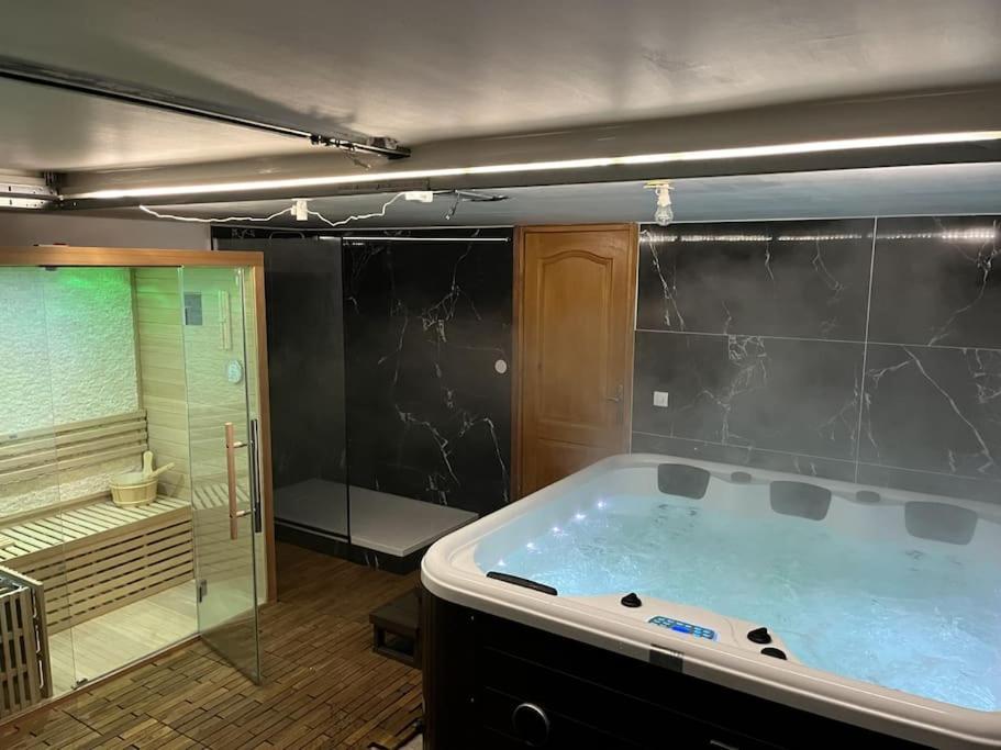 Cette chambre comprend une grande baignoire et une douche. dans l'établissement La casa del felicidad, à Bruyères-le-Châtel