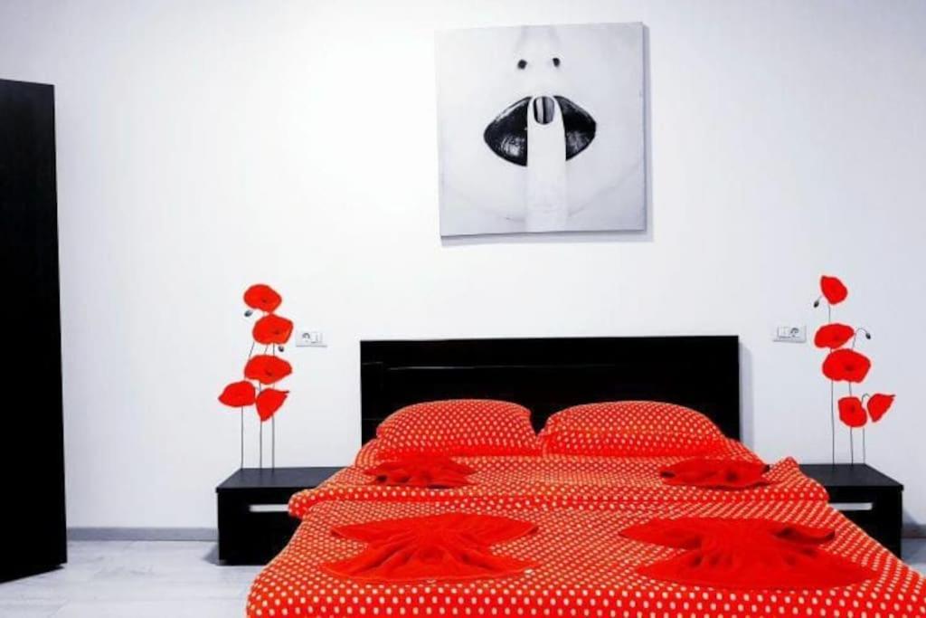 - une chambre avec un lit rouge et des oreillers rouges dans l'établissement Holiday Cazare Brasov, à Braşov