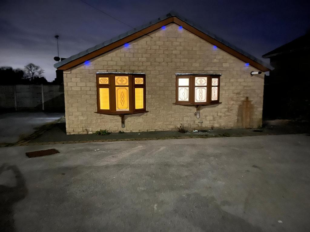 a house with two windows with lights on it at High Street Lodge in Clowne