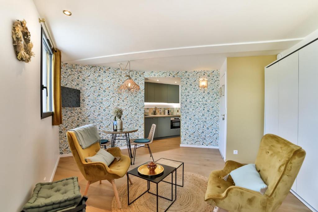 sala de estar con 2 sillas y mesa en Les Voiles - Appart'hotel Le Groix, en Carnac