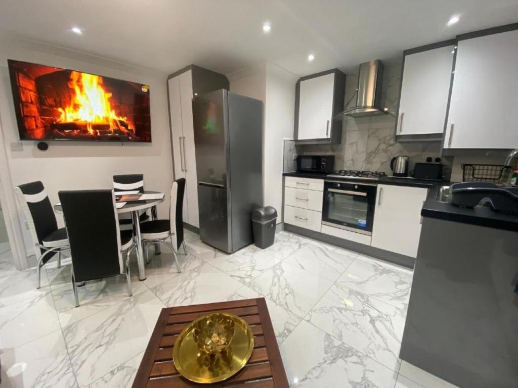 a kitchen with a table and a fire in the wall at THE ROYAL BOUTIQUE PICCADILLY LODGE by LONDON SLEEP 8 in Hayes