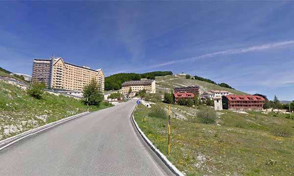 an empty road in a city with buildings on a hill at IL RIFUGIO DELLO SCIATORE/HOTEL PARADISO in Roccaraso