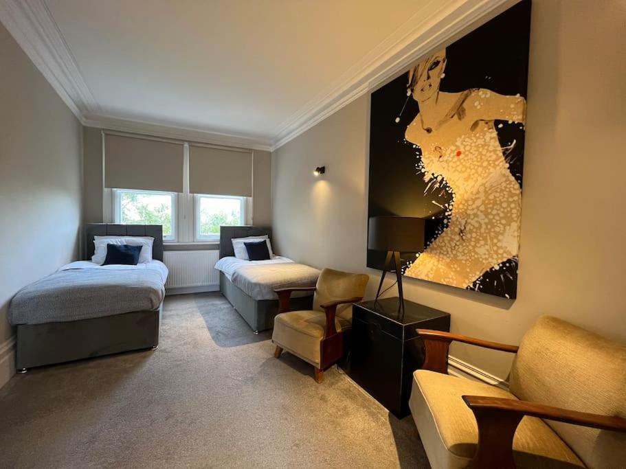 a hotel room with two beds and a couch at Star London Warwick Mansions 3-Bed Oasis in London