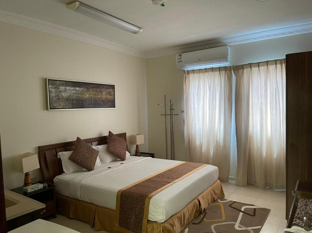 ein Schlafzimmer mit einem großen Bett in einem Zimmer in der Unterkunft السعد للشقق المخدومة in Al-Dschubail