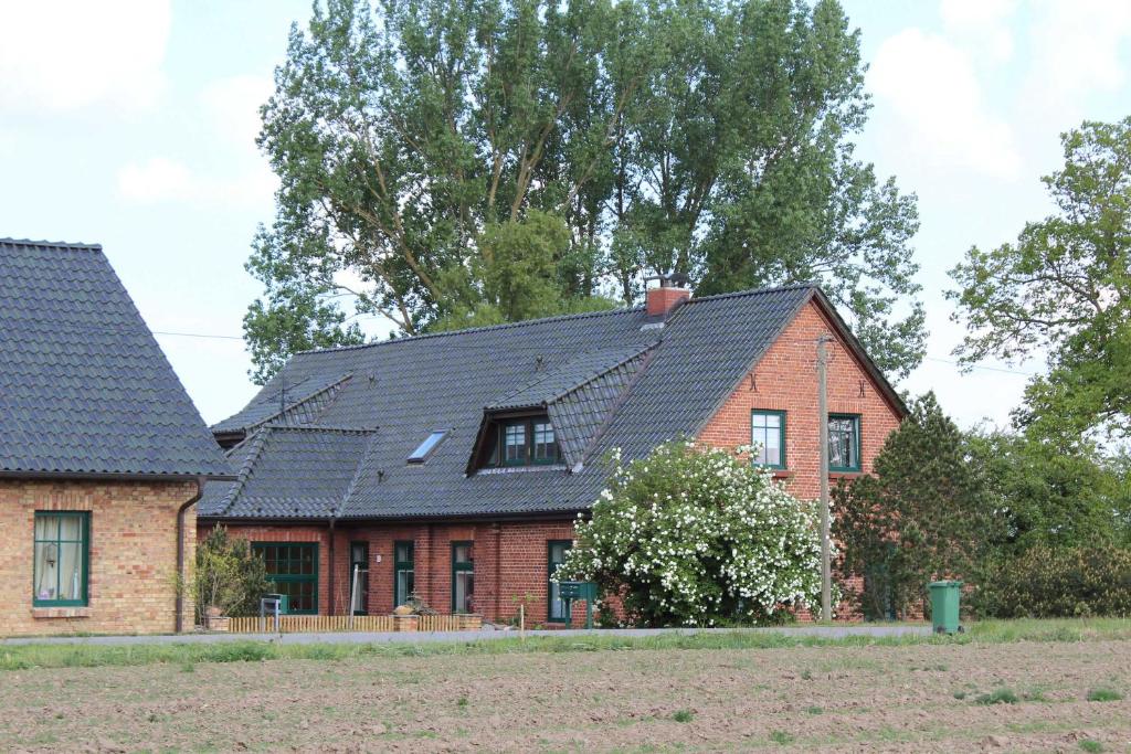 una casa de ladrillo rojo con techo negro en Ferienwohnung "Zum süßen Grund", en Groß Wokern