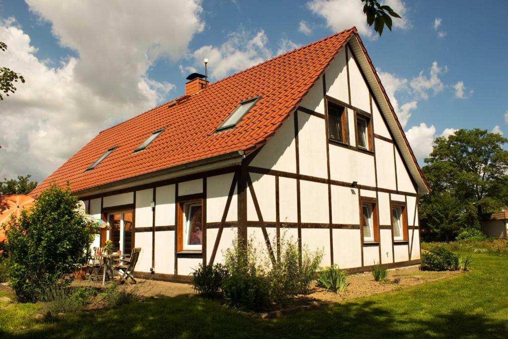 uma grande casa branca com um telhado laranja em Ferienwohnung auf dem Honighof em Krassow