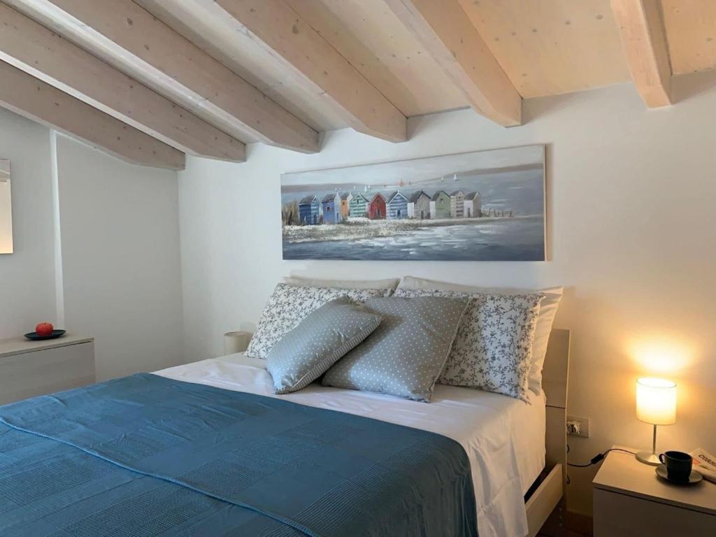 een slaapkamer met een blauw bed en een schilderij aan de muur bij The 4 Senses Experience in Suvereto