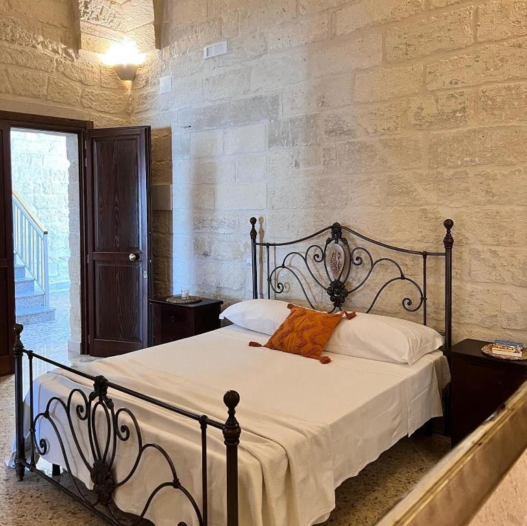 um quarto com uma cama grande e lençóis brancos em Le Casette nel Borgo em Borgagne