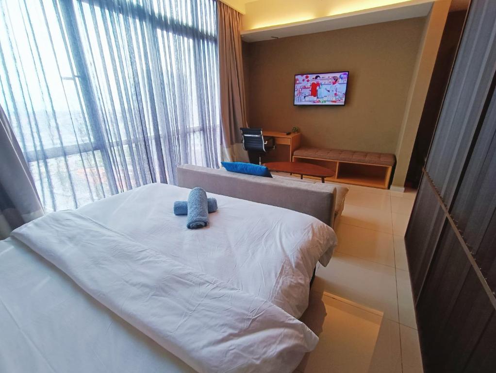 a hotel room with a bed and a tv at Pines Studio Melaka Private Suites in Melaka