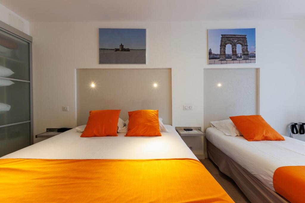 Кровать или кровати в номере Logis Hôtel Le Rochelois