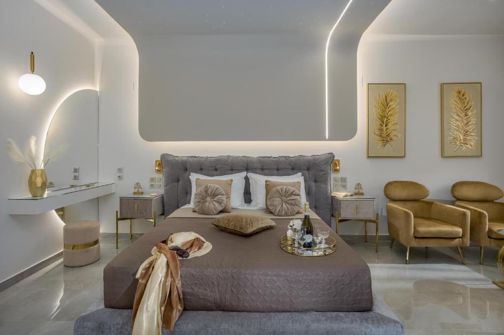 - une chambre avec un grand lit et deux chaises dans l'établissement Myra Mare Suites by Estia, à Amoudara