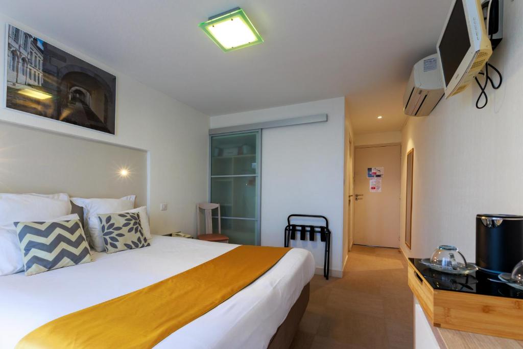 Кровать или кровати в номере Logis Hôtel Le Rochelois