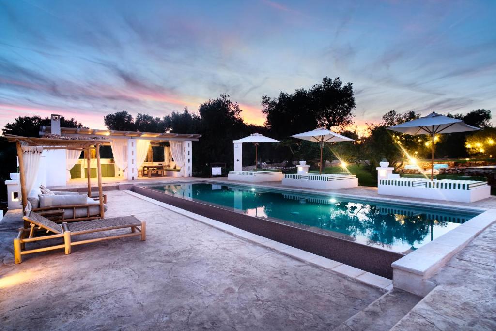 - une piscine avec une chaise longue à côté d'une maison dans l'établissement Alma Apulia " Italian Dolce Vita", à Ostuni