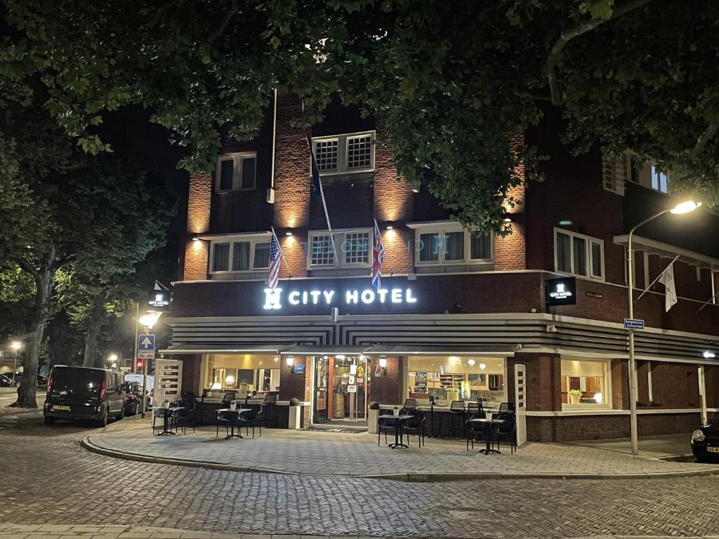Hotel auryy di notte in una strada di città di City Hotel Bergen op Zoom a Bergen op Zoom