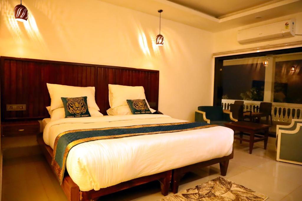 a bedroom with a large bed in a room at Panna Tiger Resort- Riverside Property in Rājgarh