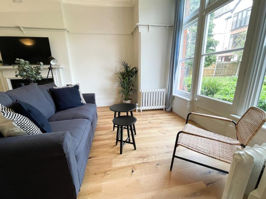 a living room with a couch and a table at Centrally located studio flat sleeps 4 in Ealing